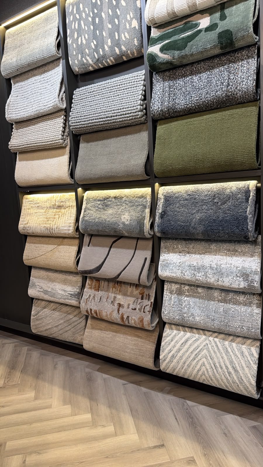 Muro de muestras de tapetes de lana, viscosa y fibras naturales en el showroom Daaq