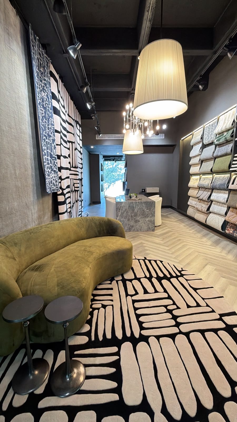Sala del showroom Daaq con tapete redondo hecho a mano y sofa verde